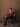 Pure Wool V-Neck Buttoned Cardigan — Camellia Red on model, seated view